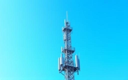 Foto di una torre di telecomunicazioni contro un cielo azzurro
